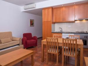 拉戈斯维塔索公园酒店的厨房以及带桌椅的起居室。
