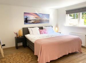 PaterswoldeB&B Hof ter Lemferdinge的一间卧室配有一张带粉色毯子的大床
