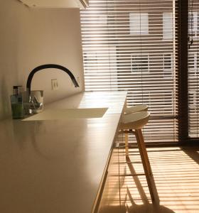 科特赖克ROOOm Kortrijk的厨房配有带水槽和凳子的台面