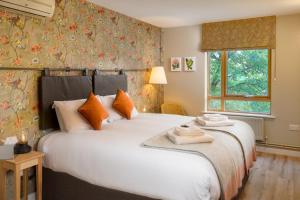 伦敦圣凯瑟琳皇家基金会酒店的卧室配有带橙色枕头的大型白色床