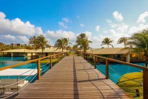 阿奎拉兹Dom Pedro Laguna Beach Resort & Golf的通往棕榈树游泳池的木制走道