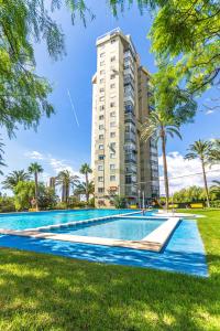 贝尼多姆Amazing Benidorm Views 2BR Flat - Pool - Parking的一座高楼前的游泳池