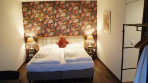 法尔肯堡Ferrum Ferrum的一间卧室配有一张带花卉墙壁的床