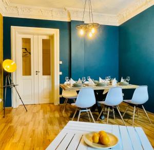 德累斯顿Edle Ferienwohnung - Industrial Style的一间拥有蓝色墙壁和桌椅的用餐室