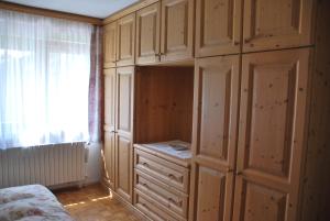 萨帕达Appartamento Anna & Gino的一间卧室设有木制橱柜、一张床和一个窗户。
