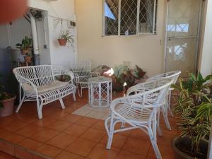 特里罗杰Le cactus guesthouse的庭院里摆放着一组白色的桌椅