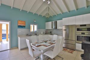 马霍礁Reflection Z 5 Star Villa的厨房配有白色的桌子和白色的椅子