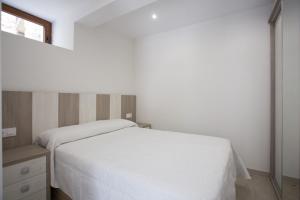 波特斯La Riega的卧室配有白色的床和窗户。