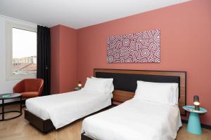 都灵CX Turin Regina Student&Explorer Place的酒店客房,配有两张床和椅子