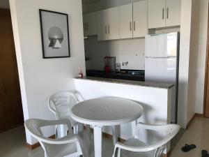 伊列乌斯Vista Mar Premium的厨房配有桌椅和白色冰箱。