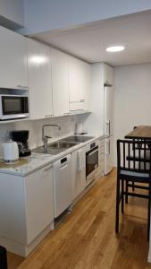 波里First Class-Annankatu的厨房配有白色橱柜和桌椅
