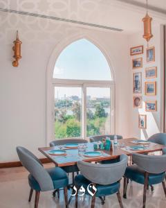 巴格达Andalus Hotel的一间带桌椅和窗户的用餐室