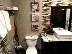 伊洛伊洛Venezia Suites Hotel Iloilo的浴室配有白色卫生间和盥洗盆。