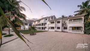 安塞奥潘嘉美拉海滩宾馆的享有棕榈树大型白色建筑的外部景色