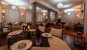 Foum ZguidHOTEL Bab Rimal的餐厅设有桌椅和吊灯。