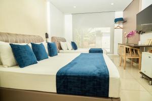 比亚维森西奥Solev Hotel的一张带蓝色枕头的大床