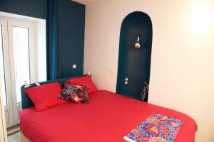 巴黎CHARMING Parisian Apartment WITH AIR CONDITIONING - CLIMATISATION & 2 BEDROOMS - Batignolles PARIS的一间卧室配有一张红色的床和黑色床头板