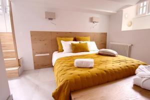 莱萨布勒-多洛讷LES CORDERIES的一间卧室配有一张带黄色毯子的大床
