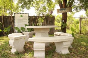 HuichihuayánHotel Vista Verde的公园里两个白色长椅和一张桌子
