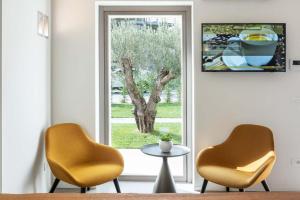 Roveredo in PianoPortone180 Guest House的窗前的两把椅子和一张桌子