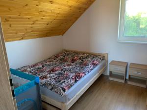 GrochowceOstoja Wilka的一张小床,位于一个拥有木制天花板的房间