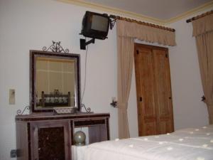 曼泰加什Descanso Serrano的一间卧室配有一张床、镜子和电视