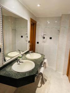 帕伦西亚斯考特而桑乔大帝酒店的一间带两个盥洗盆和大镜子的浴室