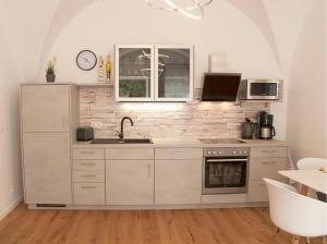 林道Appartementhaus Angelika的白色的厨房设有水槽和炉灶。