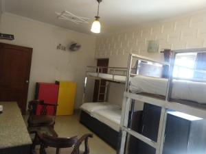 新德里国际贝索娜酒店的客房设有两张双层床和一张桌子。
