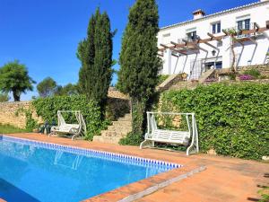 隆达Villa Casa Alta的两把白色椅子坐在游泳池旁
