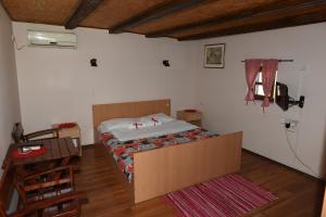 大普拉纳Etno Selo Moravski Konaci的卧室位于客房的角落,配有一张床
