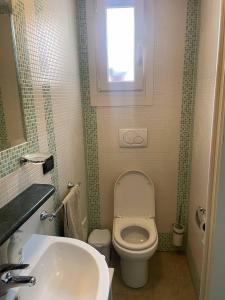 乌真托oZAN Domus的一间带卫生间、水槽和窗户的浴室