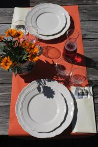 圣尼古拉斯瓦尼耶餐饮酒店的一张桌子上放着白板和玻璃杯,上面放着鲜花