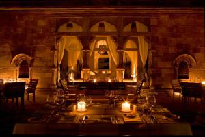 焦特布尔焦特布尔RAAS酒店的用餐室配有带蜡烛和灯光的桌子