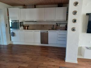 尼克宾摩斯"City Sleep"的厨房铺有木地板,配有白色橱柜。