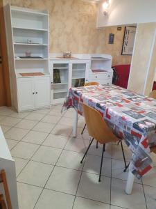 泰尔莫利Casa dell'ape Maia的厨房配有桌子和白色橱柜。