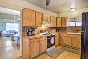 土桑Tranquil Tucson Home with Yard - Walk to U of A的厨房配有木制橱柜和炉灶烤箱。