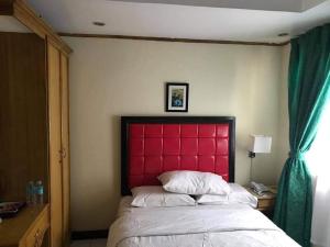 BaybayJR Pension House的卧室里一张红色床头的床