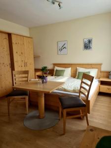 巴特霍夫加施泰因Frühstückspension Klein und Fein的卧室配有一张床和一张桌子及椅子