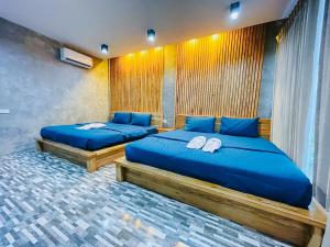 Ban Wat BoekSkyHome Wat JD I- Khai Resort & Restaurant的两张带蓝色枕头的床