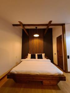 布拉索夫Colfly Studios的一间卧室配有一张大床和木制床头板