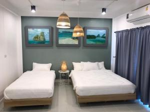曼谷Baan Suandao Wat Arun的墙上画作的房间里设有两张床