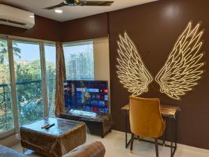孟买OSI Apartments Bandra West的客厅设有电视,墙上设有翅膀