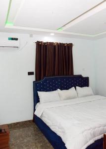 拉各斯Lords&ladies suites的卧室配有蓝色和白色的床,设有窗户