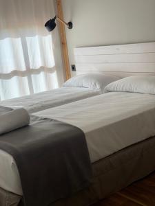 蓬特拉雷纳阿尔伯格雅酷旅舍的卧室内两张并排的床