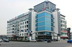 苏州锦江之星苏州吴中宝带西路店的一座大型建筑,前面有汽车停放