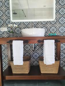 奥尔维拉Olive Tree Bed and Breakfast的浴室设有水槽、镜子和篮子