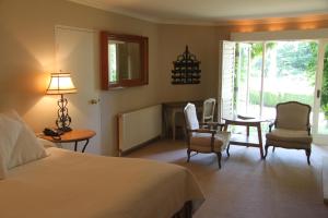 波拉尔米尔顿公园乡村度假屋酒店及Spa的卧室配有一张床和一张桌子及椅子
