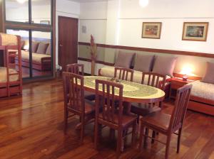 马德普拉塔家庭公寓式酒店的配有桌椅和床的房间