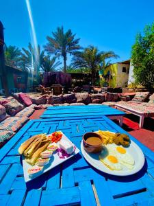达哈布Bishbishi Camp Dahab的一张桌子,上面有蓝色桌子上的早餐食品